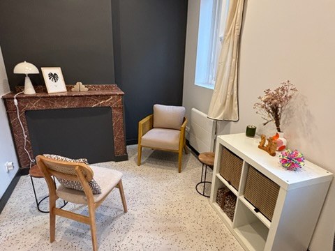 Cabinet Casa Lilas : coin consultation avec fauteuil et cheminée